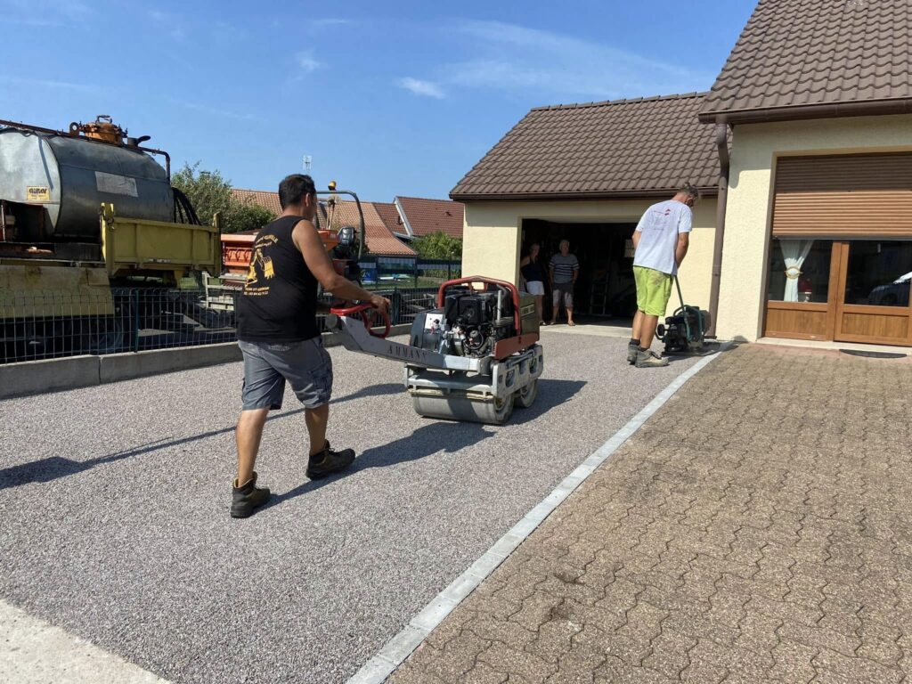 t-p-j.fr - ouvriers passant un engin pour damer une cour en bi couche