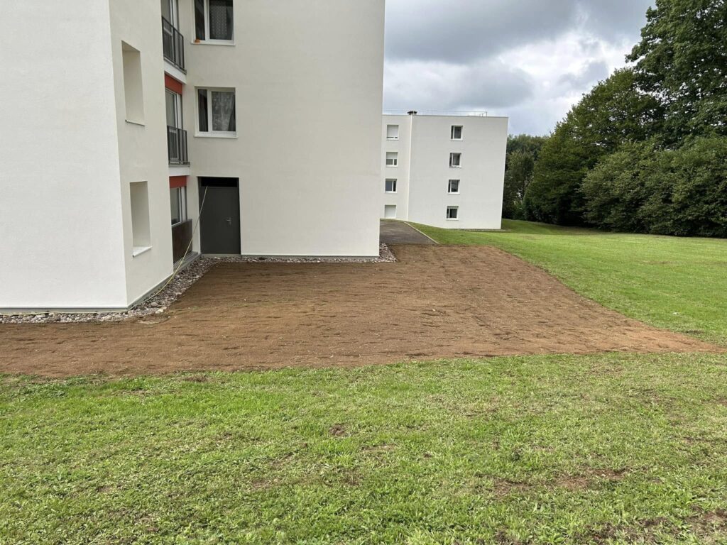 t-p-j.fr - terrain retourné prêt à semer la pelouse devant un immeuble